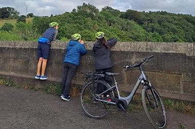 Cyclists looking off the viaduct towards Gibside