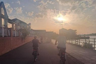 Cyclists cycling by the Staiths at sunset
